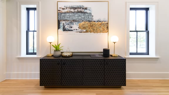 Large black cabinet with a large painting above it. 